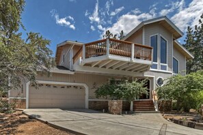 Ein zweistöckiges Haus mit Balkon, Garage und einem gepflegten Garten.