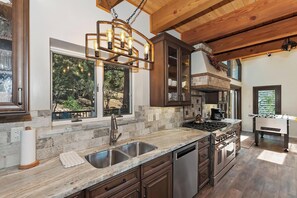 Una cocina moderna con una isla grande, electrodomésticos de acero inoxidable y vistas al exterior.