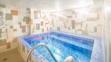 Bathroom features a rectangular bathtub and mosaic tile walls.