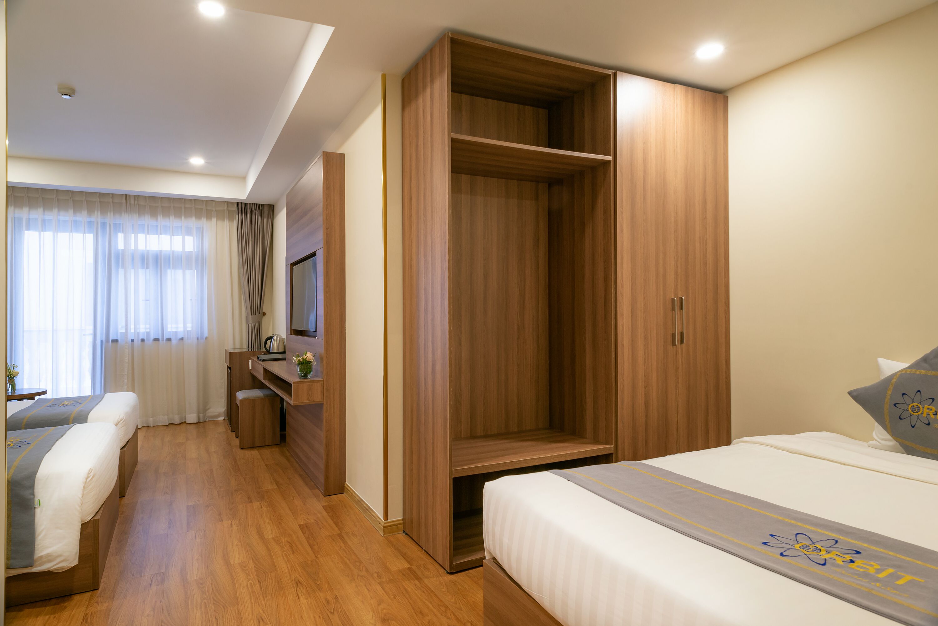 A hotel room with a bed, a desk, and a wardrobe.