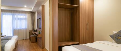 A hotel room with a bed, a desk, and a wardrobe.