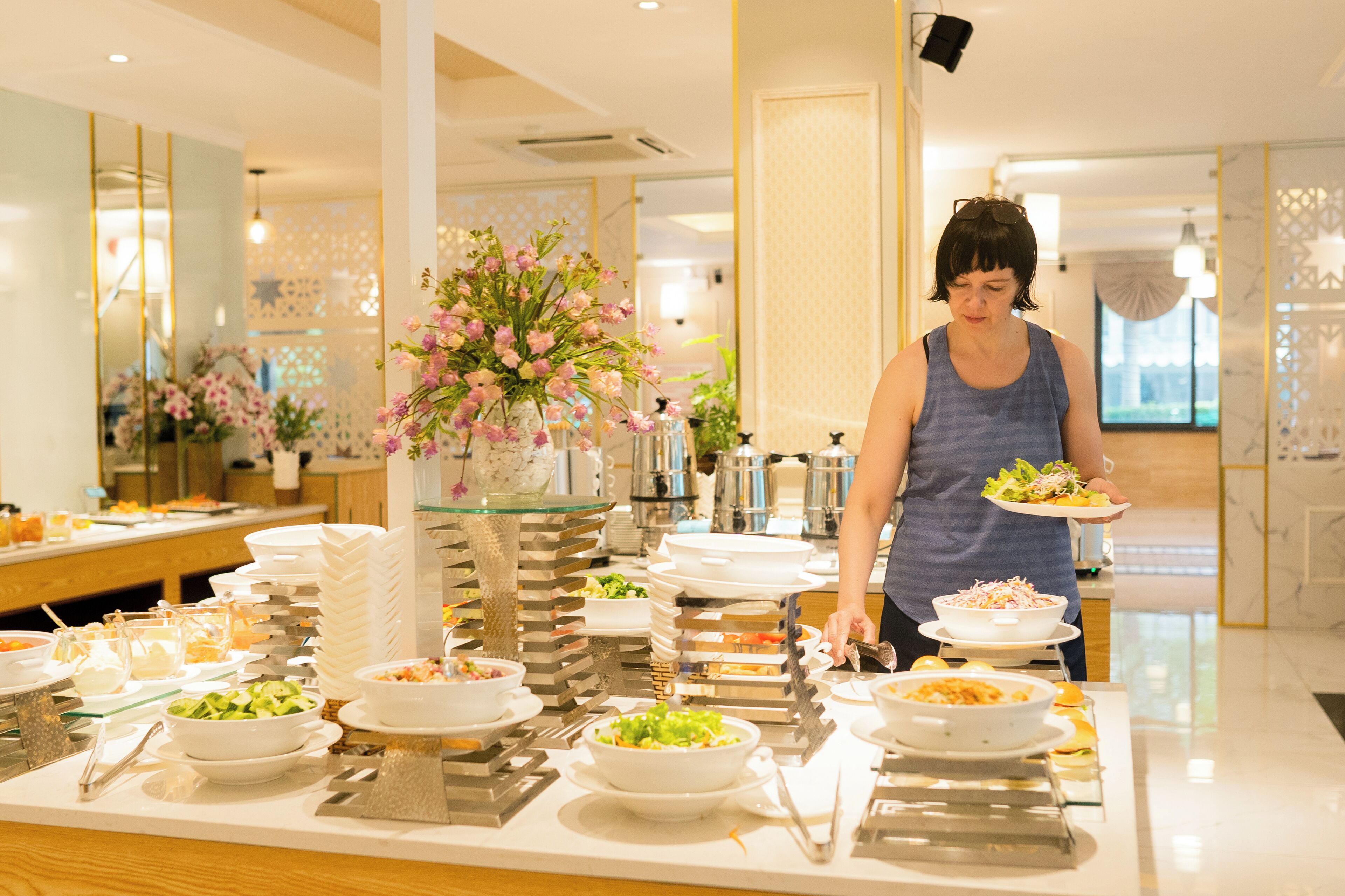 Un buffet proposant divers plats, avec une personne chargée de servir les aliments.