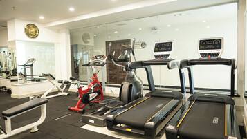 A gym with treadmills, elliptical machines, and weight benches.