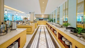 Un moderno vestíbulo de hotel con un mostrador de recepción central, una larga barra con diversos servicios y un suelo estampado.
