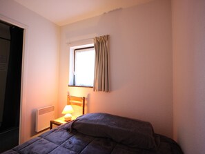 Cozy retreat with a comfortable bed, bedside table, and radiator.