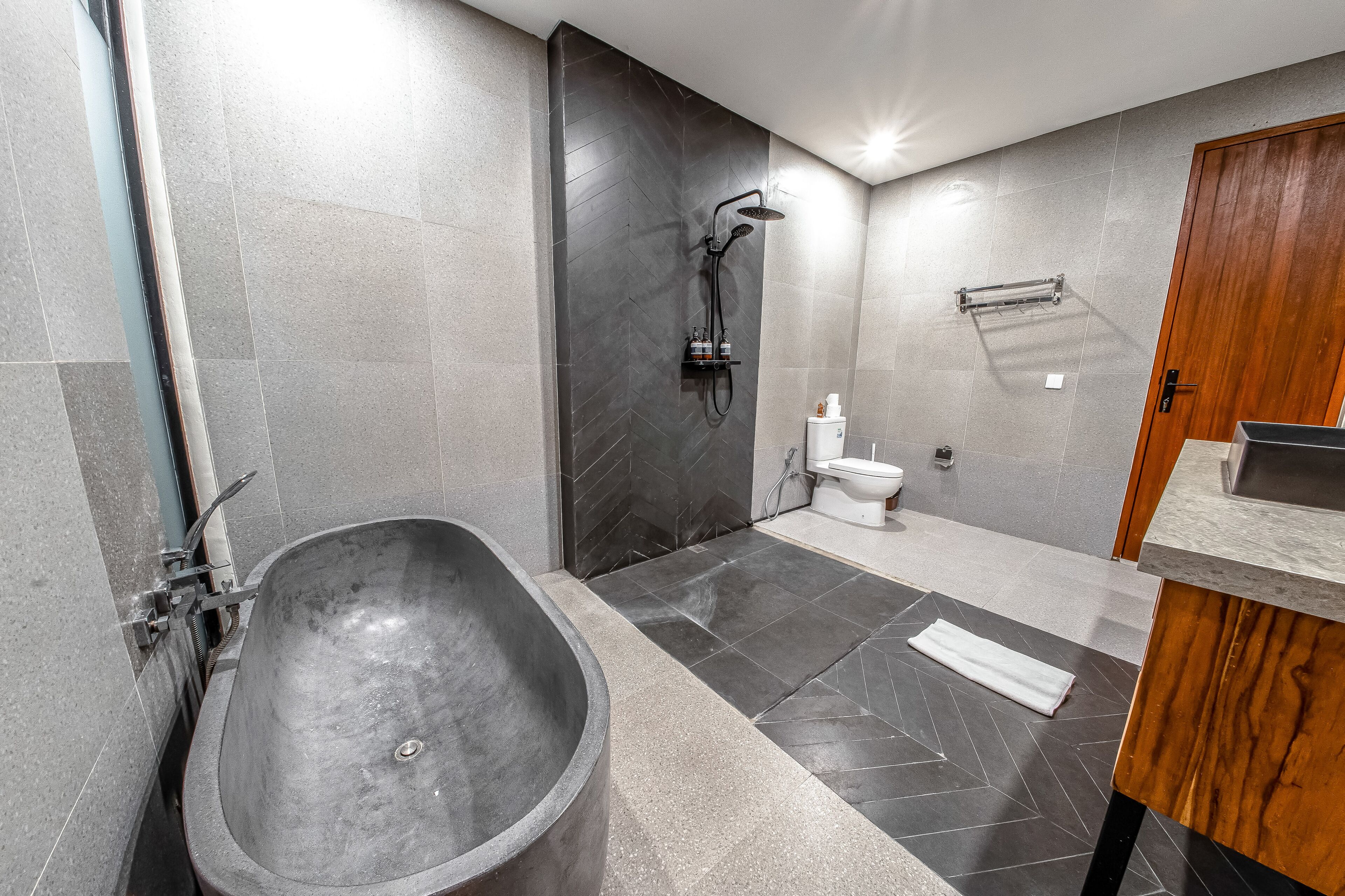 A modern bathroom with a freestanding bathtub, a shower, and a toilet.