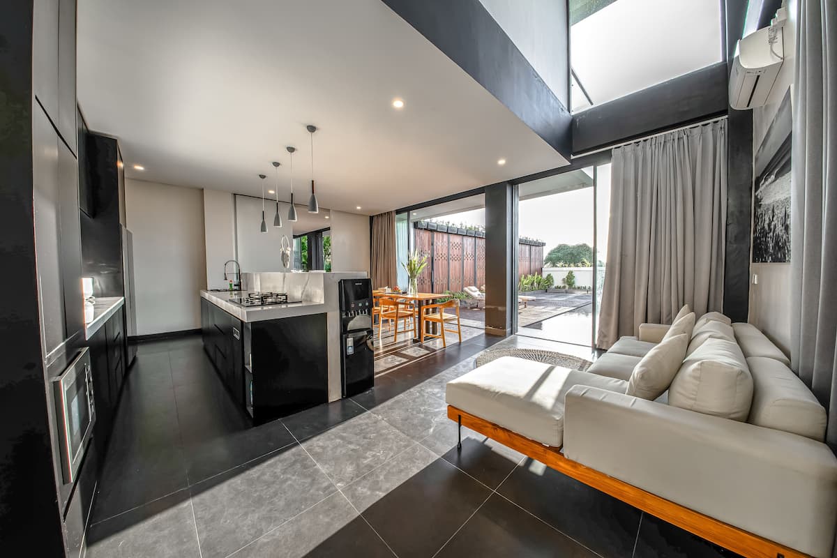 Eine moderne Küche mit Essbereich und Wohnzimmer mit Sofa.