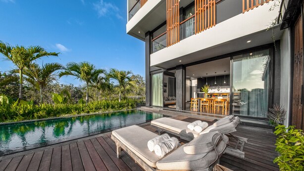 Una casa moderna con piscina, sillones de descanso y comedor.