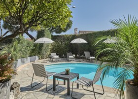 Una piscina al aire libre de temporada, sombrillas