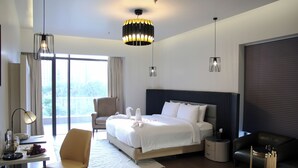 Une chambre d’hôtel moderne équipée d’un grand lit, d’un bureau, d’une chaise et d’un canapé.