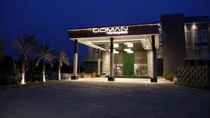 Un bâtiment moderne avec une enseigne indiquant « UDMAN » et une entrée bien éclairée.