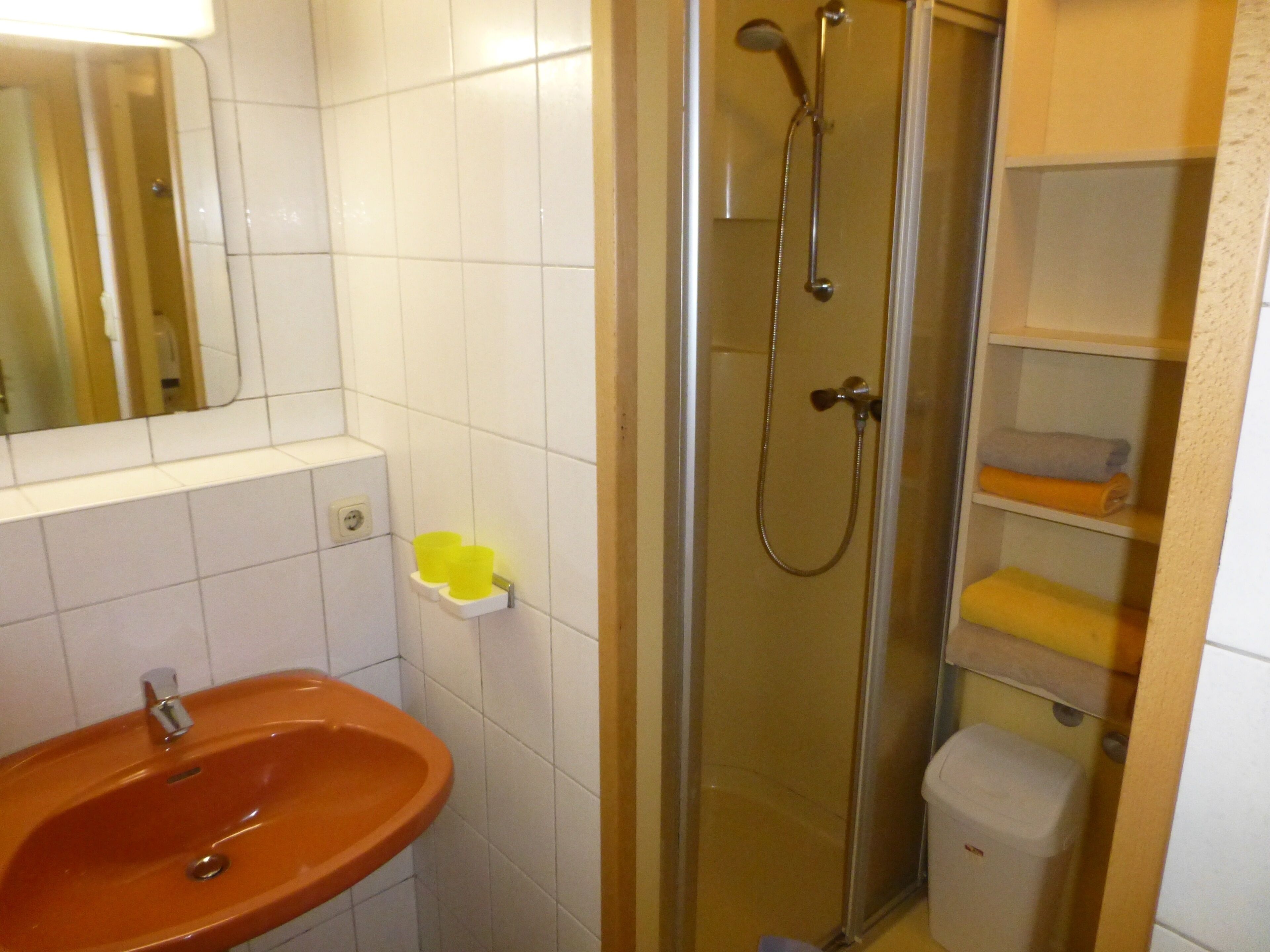 Un baño con ducha de vidrio, lavamanos e inodoro.