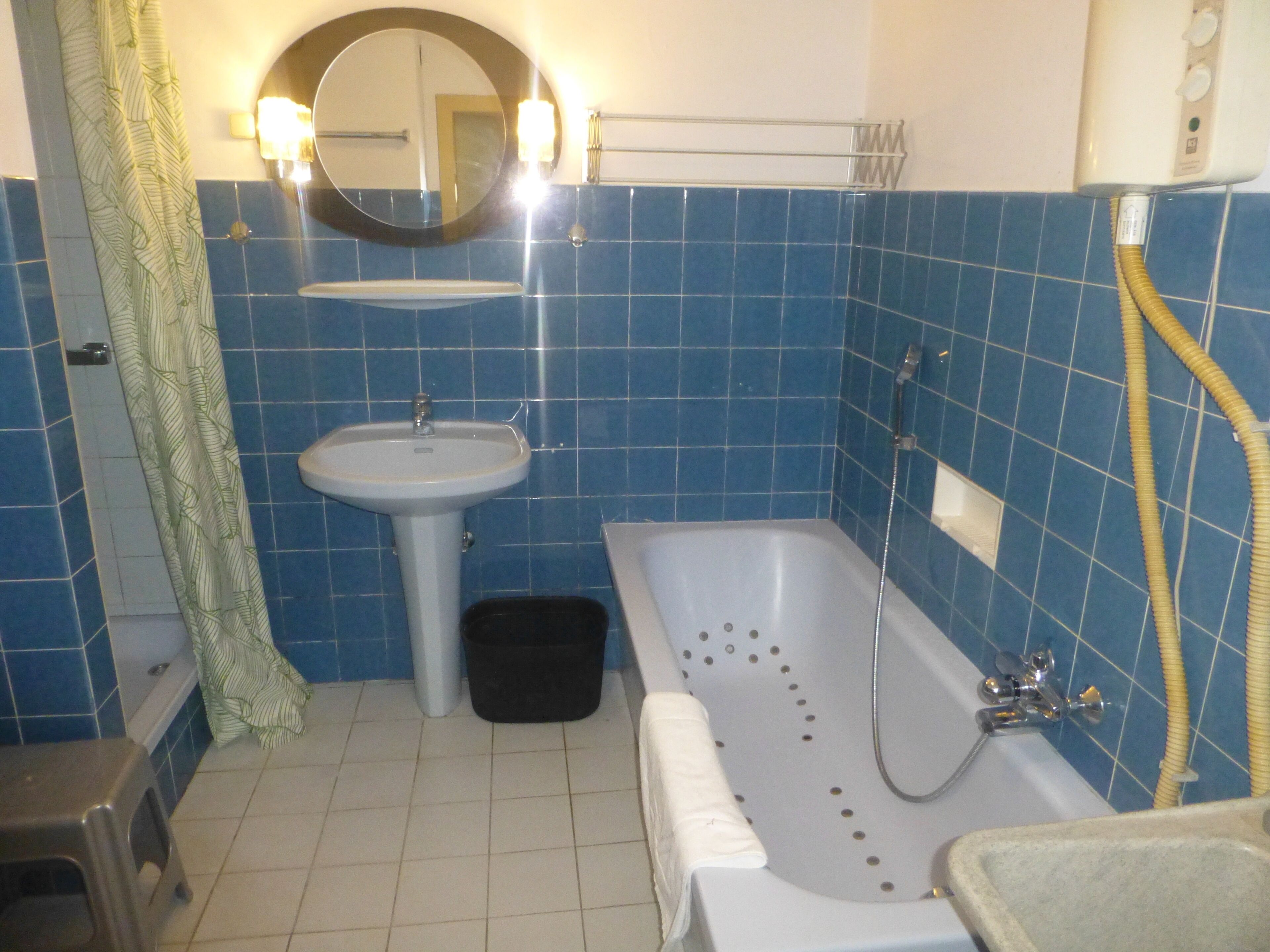 Un bagno con vasca, lavandino e doccia.