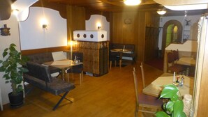 A cozy restaurant with wooden walls and a high ceiling. There are tables and chairs arranged for dining. - Smartmotel (Straß im Attergau)