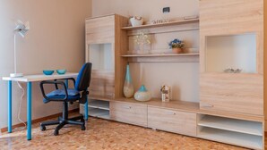 A modern room with a desk, chair, and built-in shelving with decorative items. - WATER -  WHOLE APARTMENT 4 GUESTS (Biandrate)