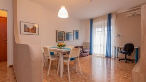 A dining area with a table and chairs, a hanging light fixture, and framed pictures on the wall. - WATER -  WHOLE APARTMENT 4 GUESTS (Biandrate)