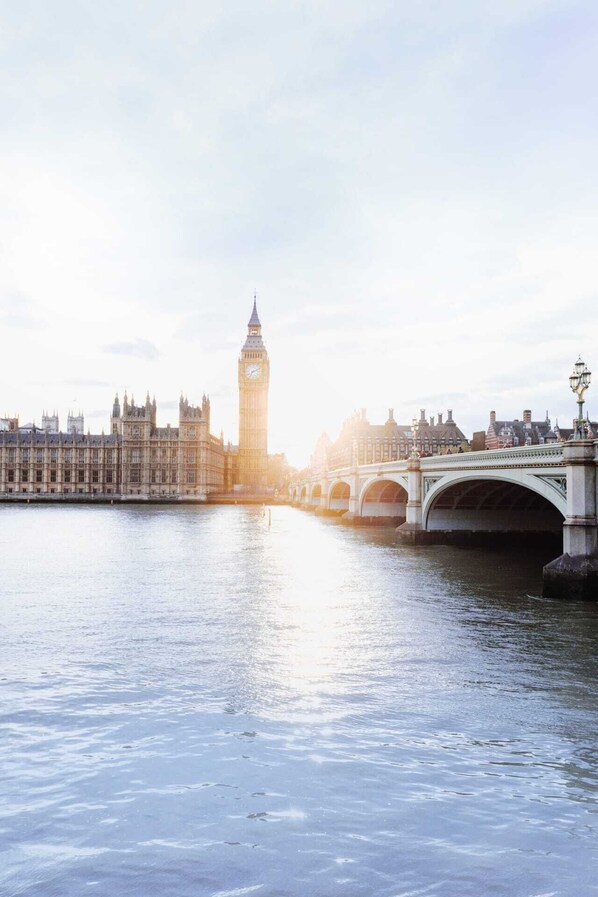 Ein Fluss mit einer Brücke und im Hintergrund der Big Ben Glockenturm.