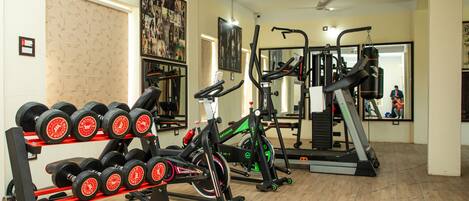 A gym with exercise equipment, including dumbbells, a stationary bike, and a treadmill.