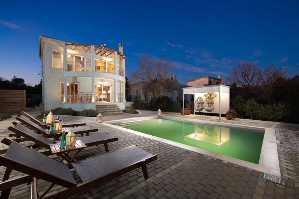 A two-story house with a swimming pool, lounge chairs, and a small gazebo. - Villa Serenity (Corfu)
