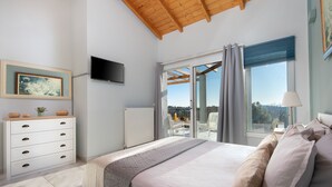 A bedroom with a bed, a dresser, a TV, and a balcony with a view. - Villa Serenity (Corfu)