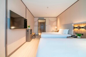A hotel room with two beds, a TV mounted on the wall, a desk with a chair, and a small table with a lamp. - Hanting Hotel (Chongqing)