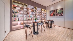 A modern library with bookshelves, a coffee table, and two chairs.