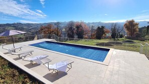 Relax by the pool surrounded by a serene landscape view.