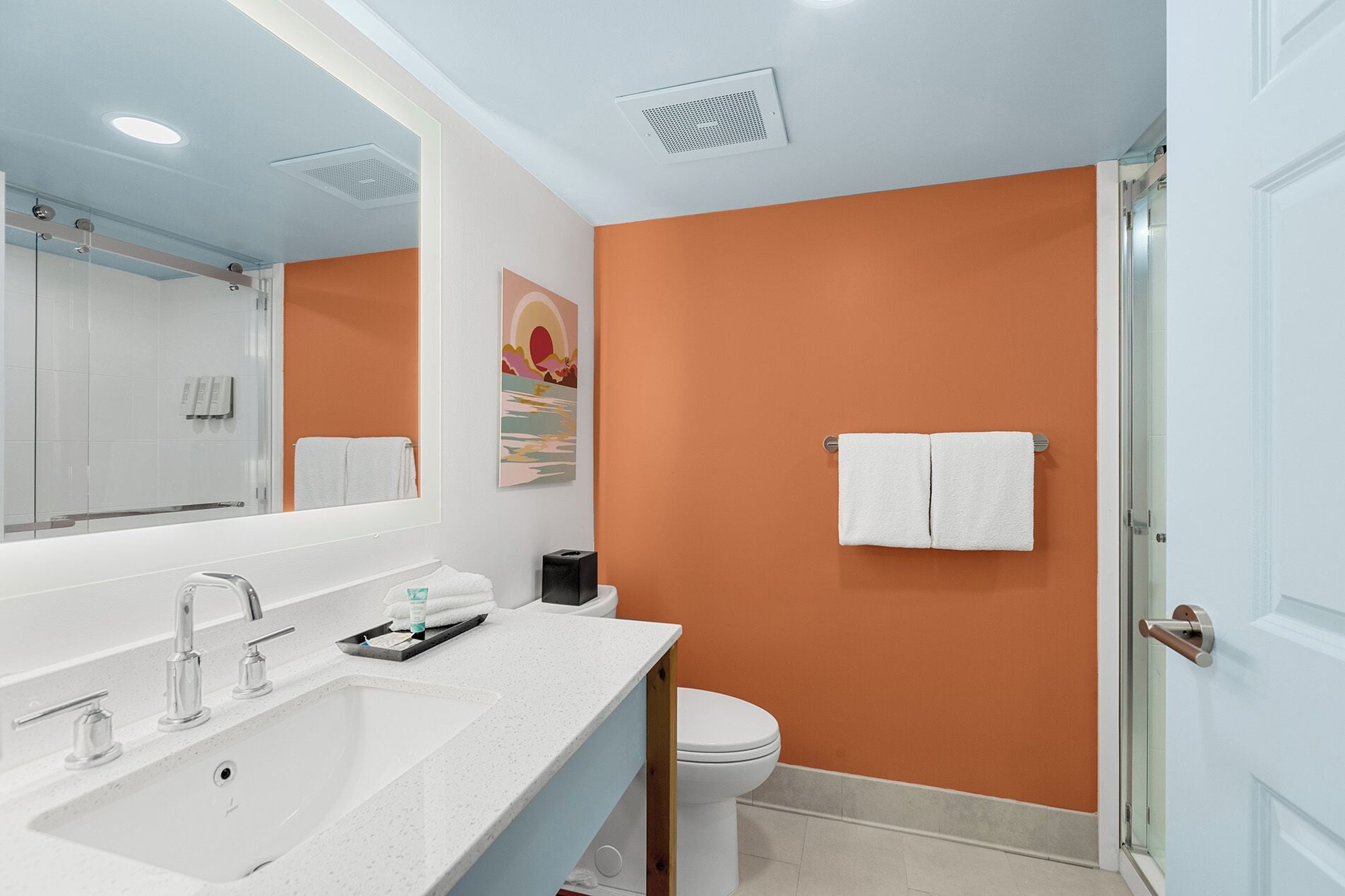 Une salle de bain moderne avec un lavabo blanc, des toilettes et une douche à parois de verre.