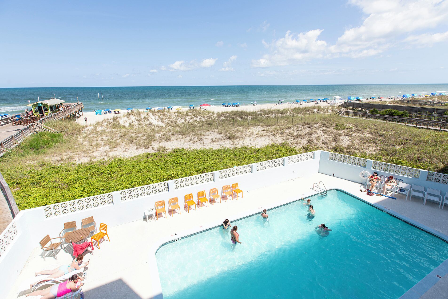 Ein Schwimmbecken mit Blick auf Strand und Meer.