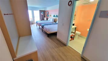 Camera d'albergo con due letti, bagno e vista sul balcone.