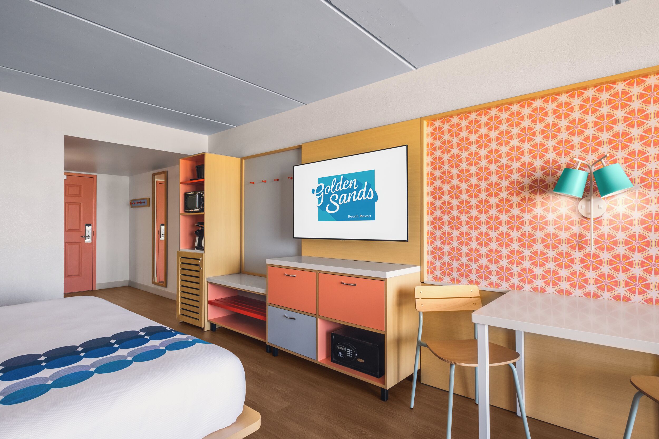 A hotel room with a bed, a desk, a TV, and a wardrobe.