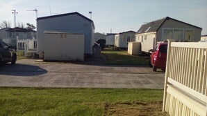 Uma fileira de casas móveis com uma área gramada em primeiro plano.