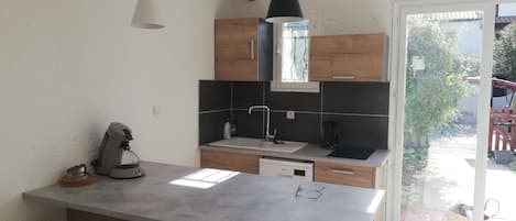 Una cocina moderna con una isla central, armarios de madera e iluminación colgante.