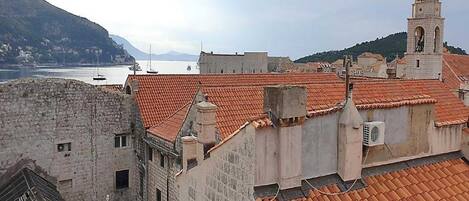 Un paisaje urbano costero con edificios históricos y una torre destacada.