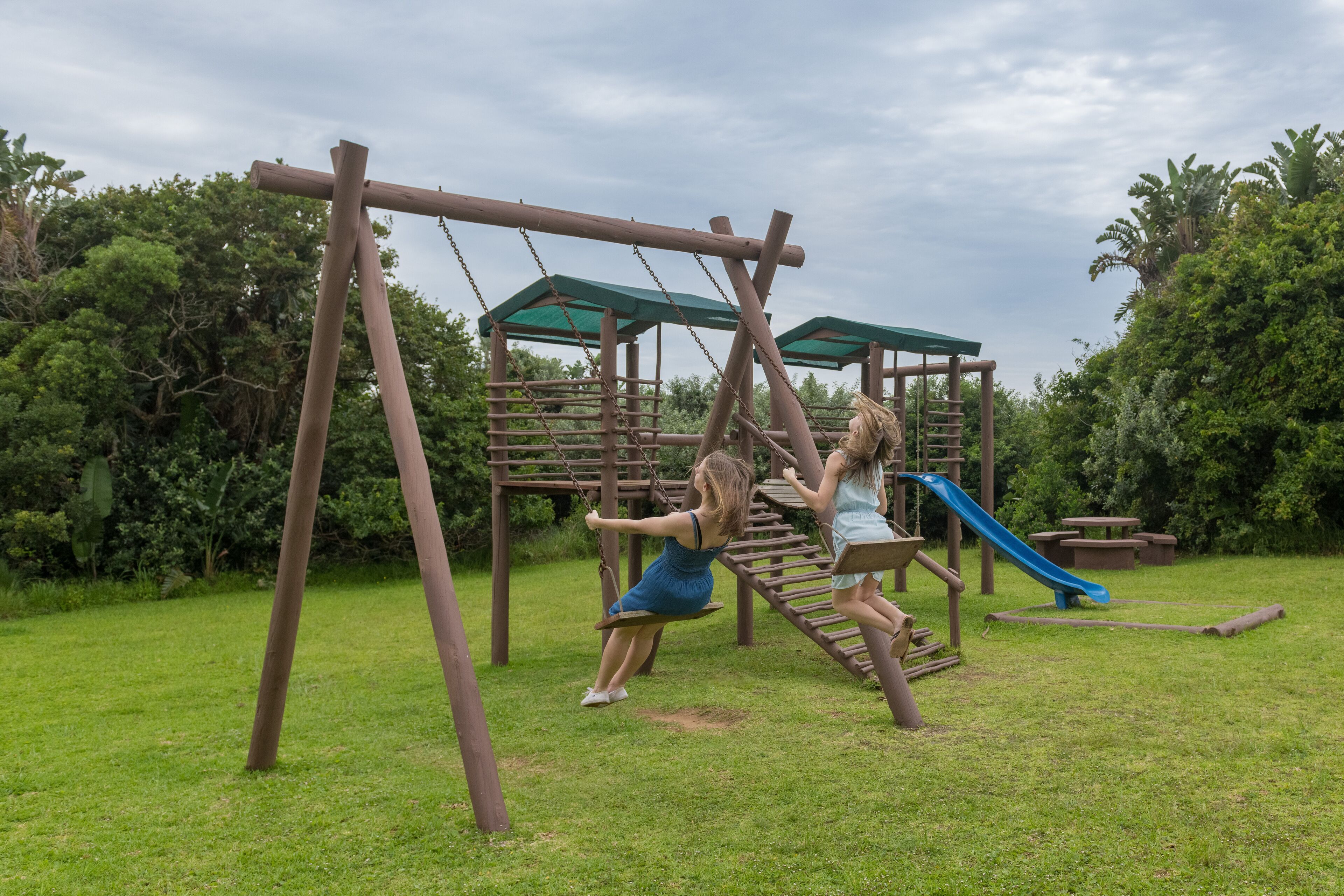 Un parque infantil con columpios y un tobogán.