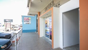 A hotel entrance with a reception desk, a blue wall, and a signboard advertising a business. - OYO Hotel Plaza Las Torres, Cabo San Lucas (Cabo San Lucas)