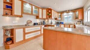 Une cuisine moderne avec des meubles en bois, un plan de travail en granit et des appareils électroménagers intégrés.