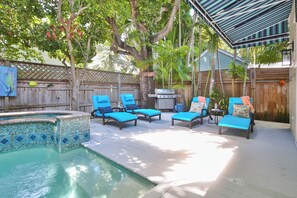 A backyard with a swimming pool, lounge chairs, and a barbecue grill. - LOVE LANDING ~ Charming 3 Bedroom, 3 Bathroom Home w/ Pool and Parking! (Key West)