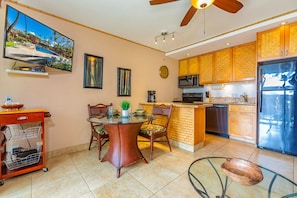 A modern kitchen with a refrigerator, microwave, and a dining area with a table and chairs.