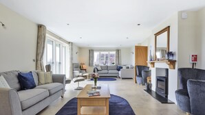 A spacious living room with a sofa, a coffee table, and a fireplace. - All Views, Burton Bradstock, Bridport (Bridport)