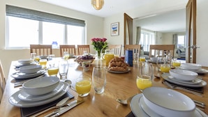 A dining table set with plates, bowls, glasses, and a pitcher of orange juice. - All Views, Burton Bradstock, Bridport (Bridport)