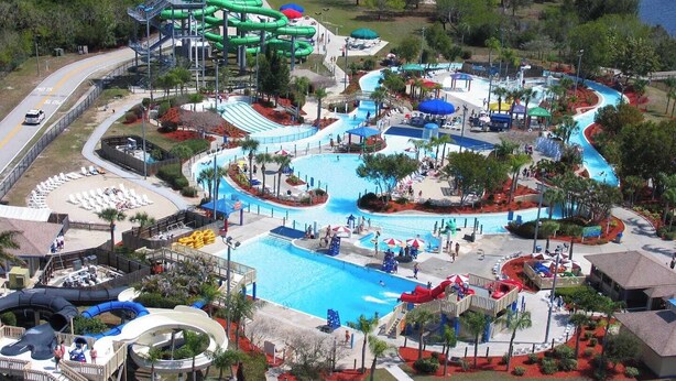 A water park with a large pool, multiple slides, and a winding water ride. - Family Oasis: Waterfront Heated Pool & Game Room (Cape Coral)