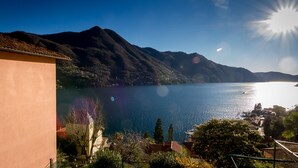 Un lago con montañas al fondo, cielo despejado y un edificio en primer plano.