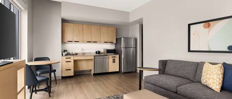 A modern apartment with a kitchen, dining area, and living room.