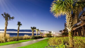 A pathway leading to a building with a view of the ocean. - Hyatt Place Virginia Beach / Oceanfront (Virginia Beach)
