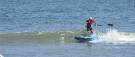 A person paddleboarding on a calm body of water.