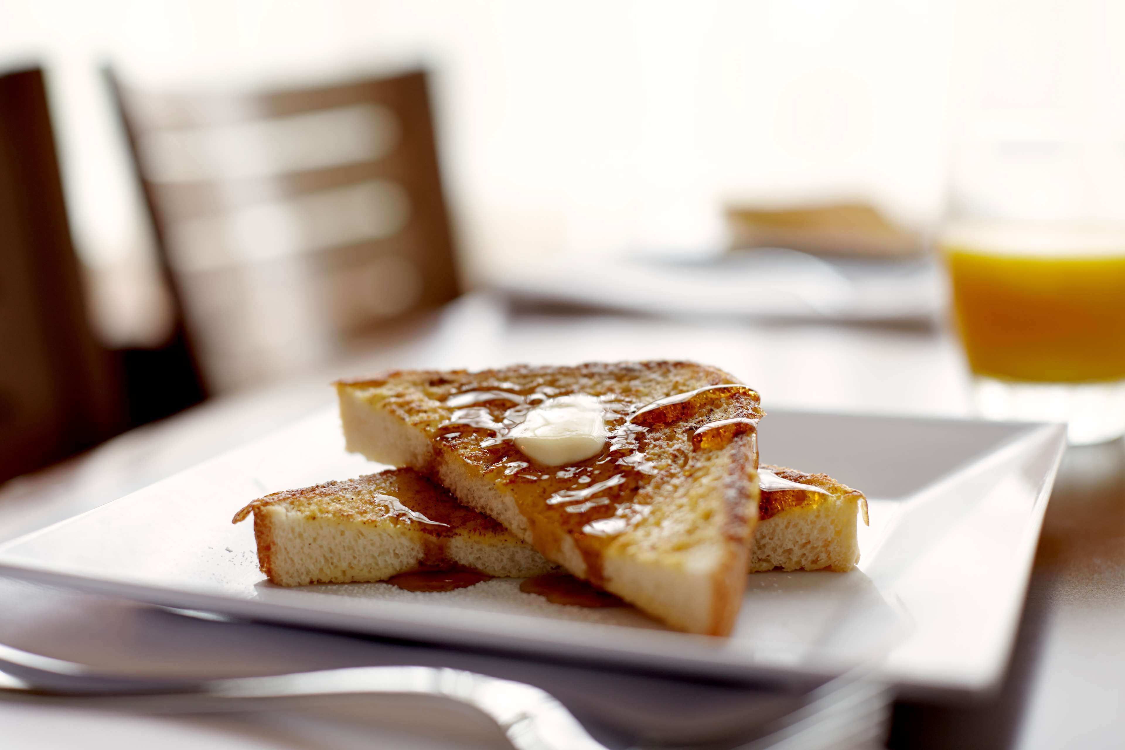 A breakfast plate with toast, butter, and syrup.