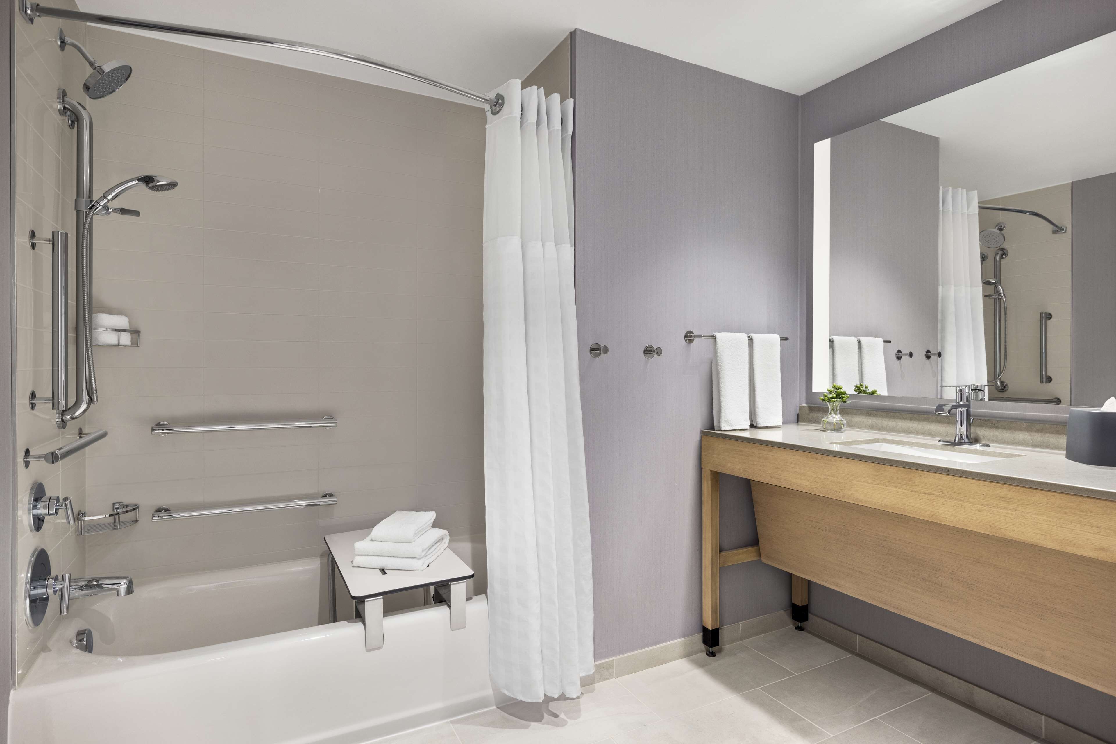 Une salle de bain moderne avec une baignoire, une douche et un meuble-lavabo.