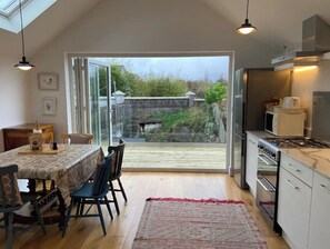 A modern kitchen with a dining area, large windows, and a view of the garden. - Chic hideaway in the centre of Kenmare (Kenmare)