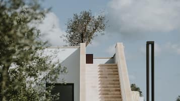 Un edificio moderno con una escalera que lleva a un jardín en la azotea.